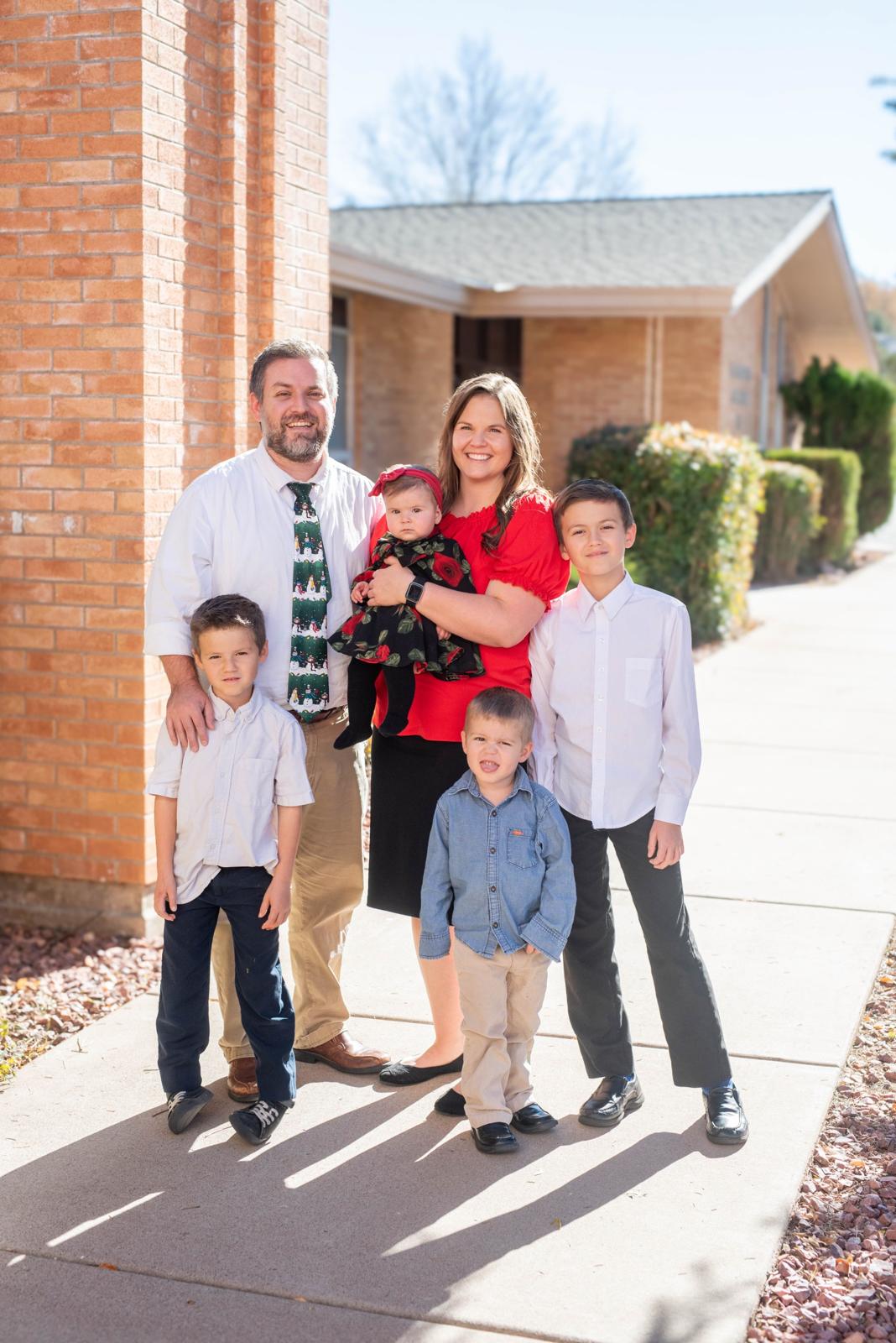 Family of six dressed up and posing together outside a church