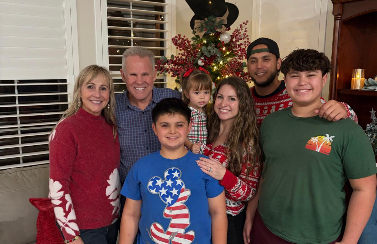 Family gathered together in front of a Christmas tree