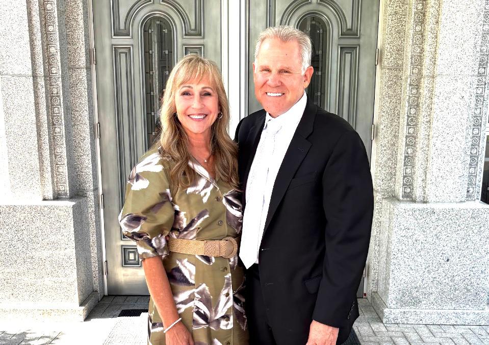 Couple dressed up and smiling in front of a stone building